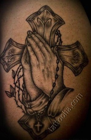 Руки молящегося на фоне креста