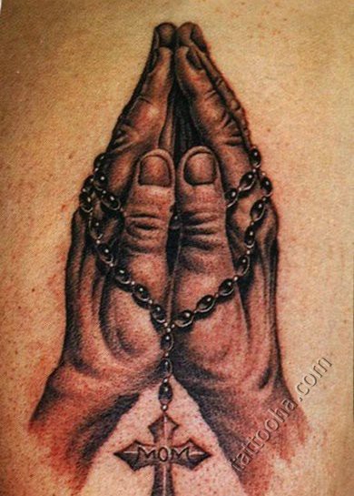 Руки молящегося с крестиком на четках